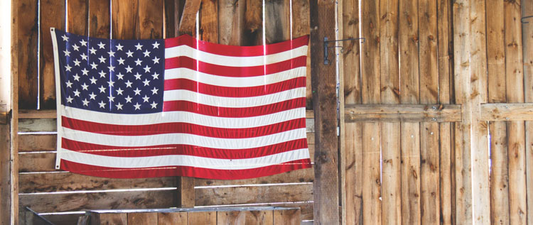 The American flag hangs on a barn wall