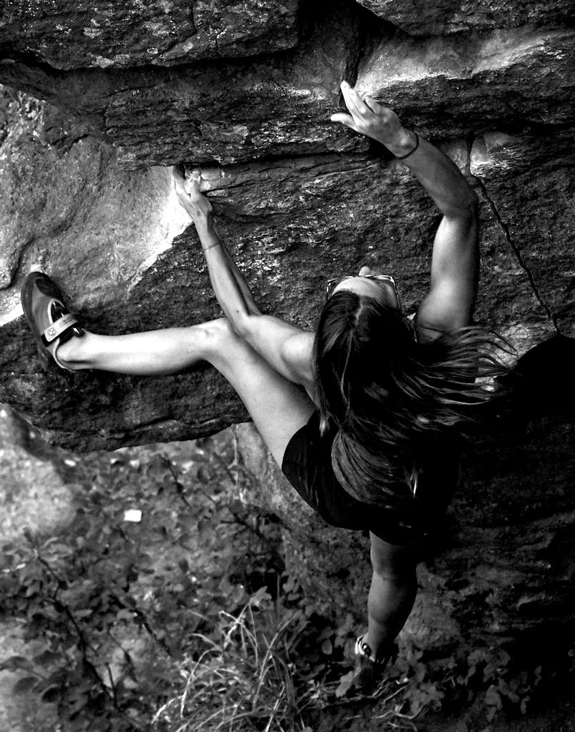 A woman climbs a rock face